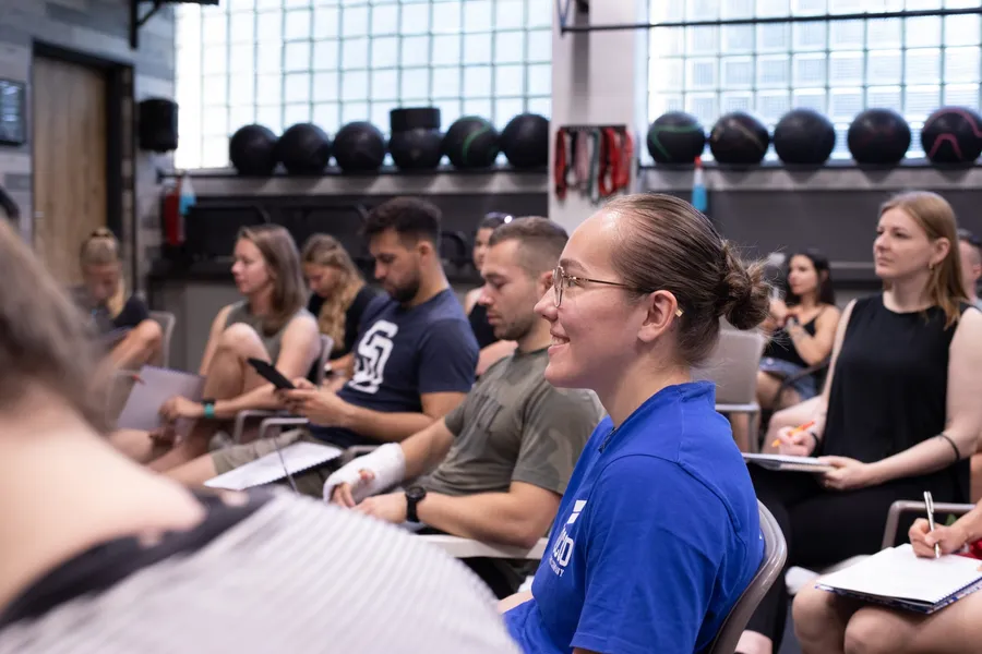 Účastnice semináře o ženském cyklu sledují přednášku ve fitness centru