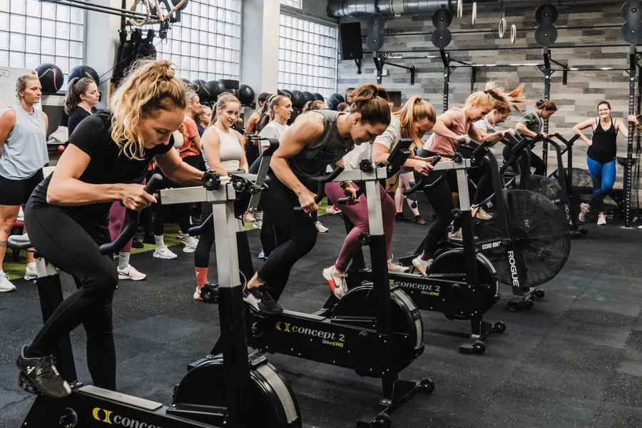 Skupina žen cvičí na veslovacích trenažérech Concept2 BikeERG ve fitness centru