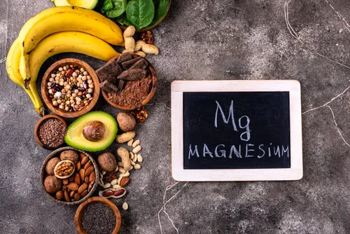 Potraviny bohaté na hořčík – ořechy, banány, avokádo, luštěniny a tabulka s nápisem Magnesium